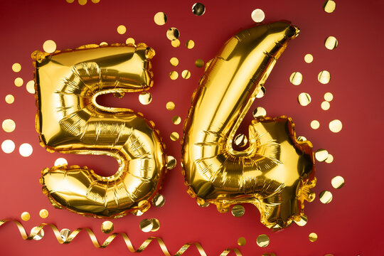 54th birthday celebration. Gold festive balloons number 54 year anniversary on red background with confetti. Birthday or wedding event.