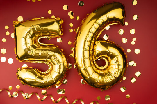 56th birthday celebration. Gold festive balloons number 56 year anniversary on red background with confetti. Birthday or wedding event.