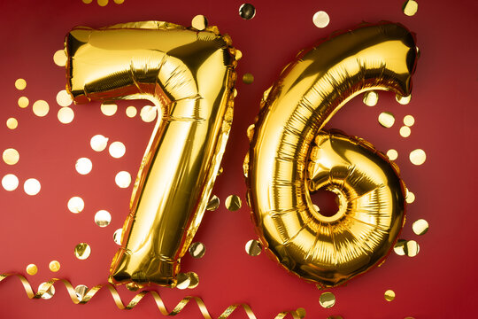 76th birthday celebration. Gold festive balloons number 76 year anniversary on red background with confetti. Birthday or wedding event.