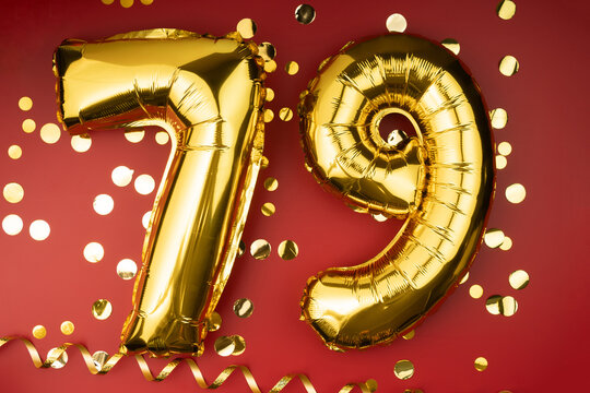 79th birthday celebration. Gold festive balloons number 79 year anniversary on red background with confetti. Birthday or wedding event.