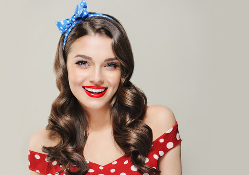 A Pin Up smiling young woman in a retro outfit  showcasing an invisible Presenting your product .Beautiful smile vintage girl with curly hair  .Expressive facial expressions. wavy hairstyle