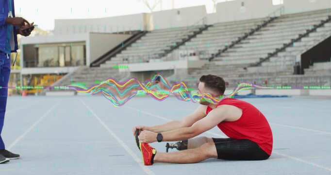 Stretching bladed athlete in red top on track warming, while coach coming left with phone data