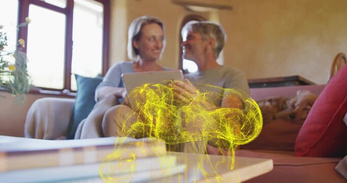 Mature couple tapping tablet, sharing and causing tech glow rising from table, clarifying faces