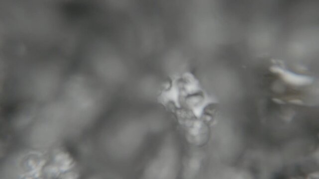 Underwater POV of fresh water flowing from a fountain tap with bubbles.