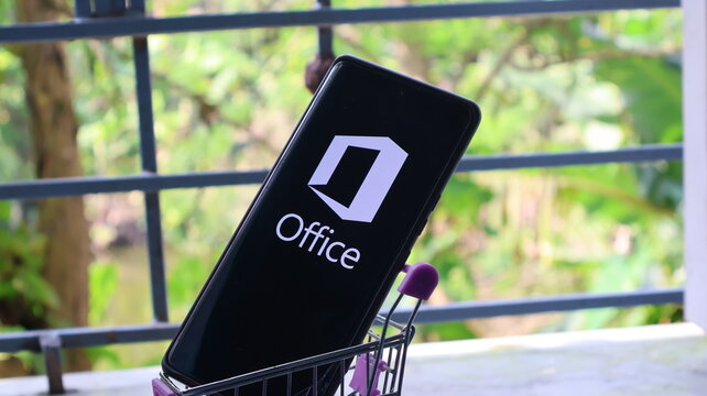 A smartphone with Microsoft Office displayed on its screen in a small shopping cart