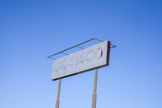 Seligman, Arizona - March 28. 2026: Old faded Texaco gas station sign along Route 66 against a blue sky
