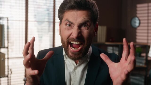 Mad Caucasian middle-aged business man yelling at camera furious adult businessman 40s male agent mental pressure panic attack suffering work stress yell shouting angry worker shout scream in office