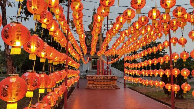 Chinese lanterns in the temple. Rows of traditional red Chinese paper lanterns hanging from wires in front of a Buddhist