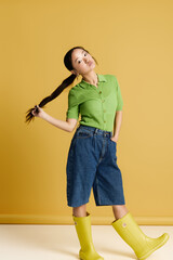 Stylish young woman showcases vibrant fashion with a playful twist against a sunny backdrop