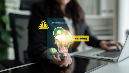A woman in a modern office setting receives an incoming call notification on her smartphone. The image highlights the blend of technology and communication urgency with a light bulb. Gantry © InfiniteFlow
