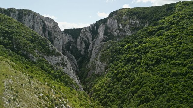 Reveal Flying Into Turda Gorge in Romania with Towering Limestone Spires and Lush Green Forest Filling the Narrow Rocky Canyon