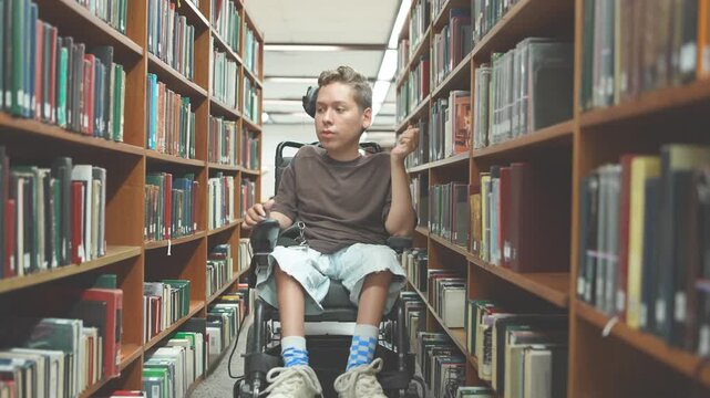 Independent Student in Power Wheelchair Searching for Books in Library Aisle