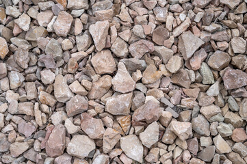 Naklejka premium Texture of gray crushed gravel stones on the ground, full frame background