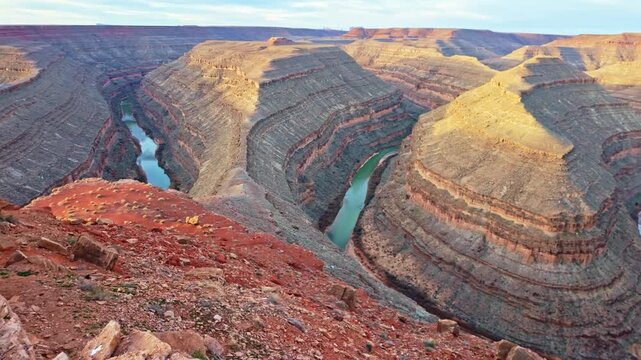 Sunrise view of winding river bend carving deep canyon at Goosenecks State Park desert landscape
