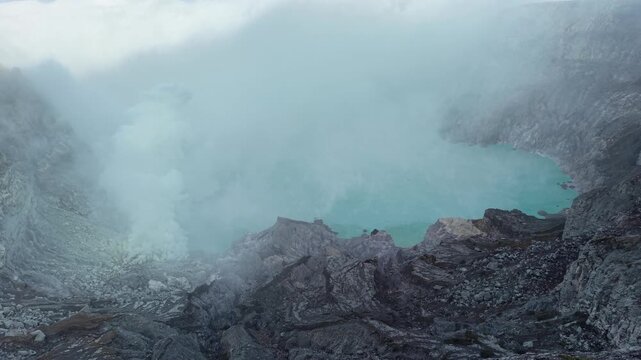 Mount Ijen volcano aerial sunrise with crater lake and fog, East Java Indonesia. Cinematic volcanic landscape, ideal for travel, nature, and adventure video projects.