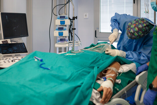 Medical team performing catheterization procedure on patient in operating room