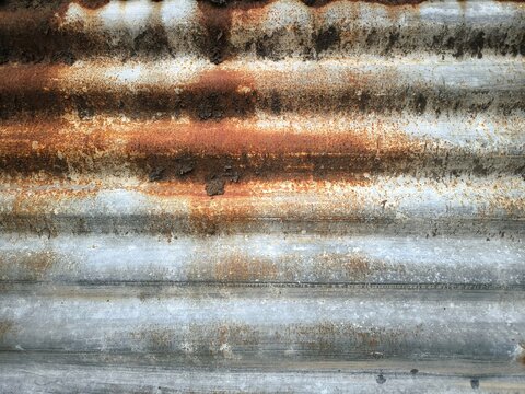 Texture of old rusty corrugated metal sheet with weathered surface