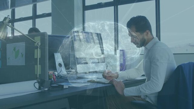 Male worker picking pen, writing in business, brain overlay forming on monitors guiding focus