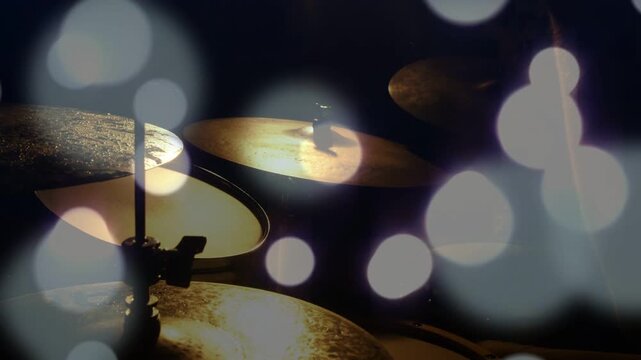 Drummer hands entering and striking cymbals, making music rhythm highlights, bokeh overlay shifting