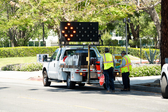 Road crew workers directing traffic with a truck and arrow board