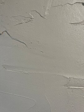 Abstract textured surface of drying grey wet plaster with raised ridges