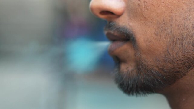 Man Smoking Cigarette Close-Up with Dramatic Lighting