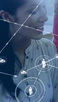Vertical video: Seated woman leaning, team reaching causing linking nodes and user icon for tech