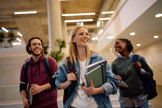 Happy student and her friends going on lecture at university.