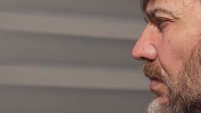 Side profile of bearded man wearing glasses in sunlight