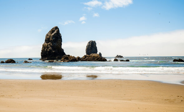 Visitors enjoying a sunny day at Cannon Beach, Oregon.