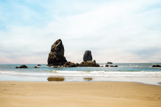 Visitors enjoying a sunny day at Cannon Beach, Oregon.