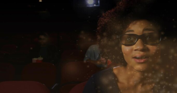 Woman in 3D glasses reacting to projector in cinema, particles crossing over her, eating popcorn