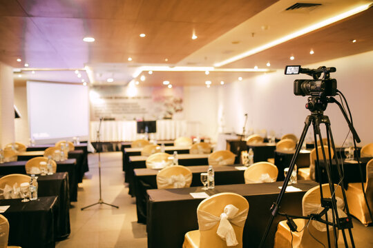 Empty Conference Room Setup with Chairs and Camera on Tripod for Corporate Event.