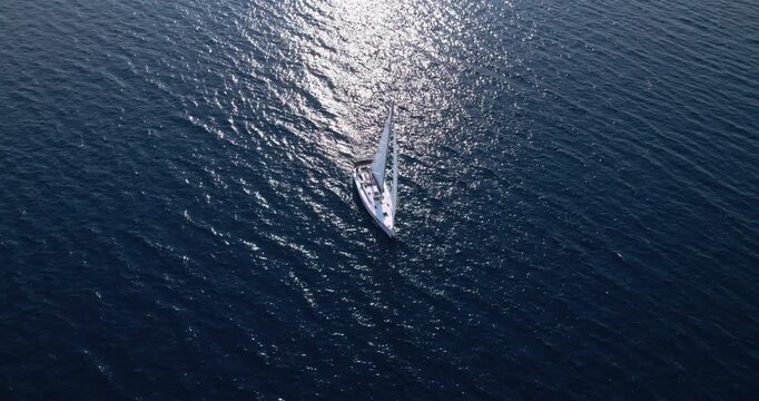 Gleaming Sunlight Reflecting Off Peaceful Blue Sea While Boat Sails. Golden Sunlight Sparkles On Calm Deep Blue Waters As Sailboat Progresses Smoothly Through Open Ocean