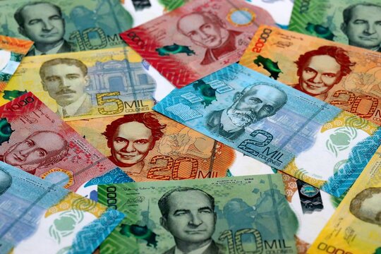 Costa Rican new colon money banknotes pile on table. Costa Rica bills of CRC currency close up