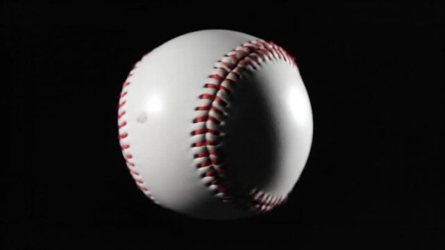 Baseball in the Spotlight: The quintessential baseball, a symbol of sport and Americana, floats in dramatic contrast against the inky black backdrop, showcasing its intricate stitching and pristine.