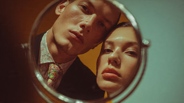 Reflet d'un couple jeune se regardant dans un miroir rond
