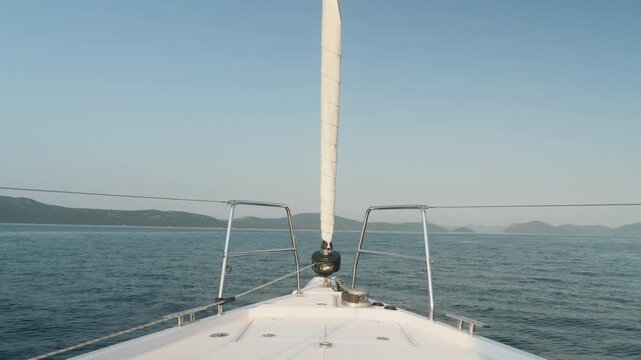 Mast View Over Open Sea Horizon, Long Calm Passage Under Clear Blue Sky, Distant Island Silhouettes And Gentle Swell Suggesting Slow Cruise And Reflective Mood