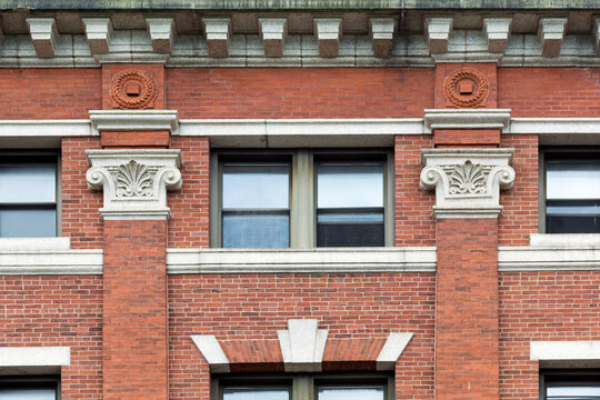 Historic red brick facade in Cambridge featuring white Ionic capitals on brick pilasters
