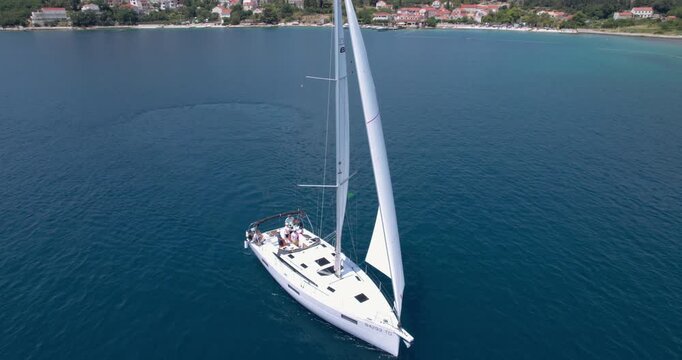 Beautiful white sailing yacht anchored in Adriatic Sea bay in Slano, Croatia. Sail experience on shared sailboat with group of friends on holiday.