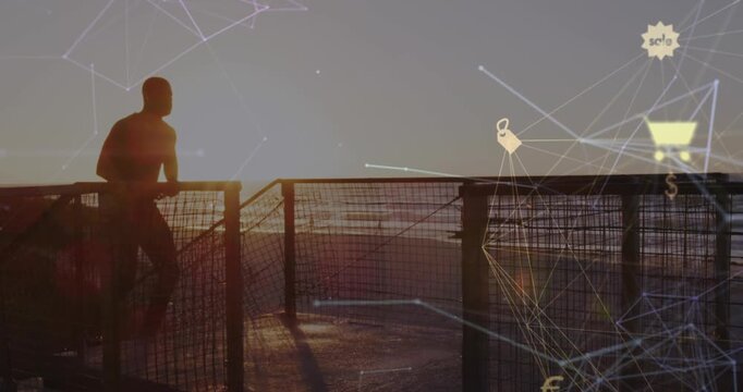 Animation of connected icons globe over silhouette on man running up stairs at beach after jogging