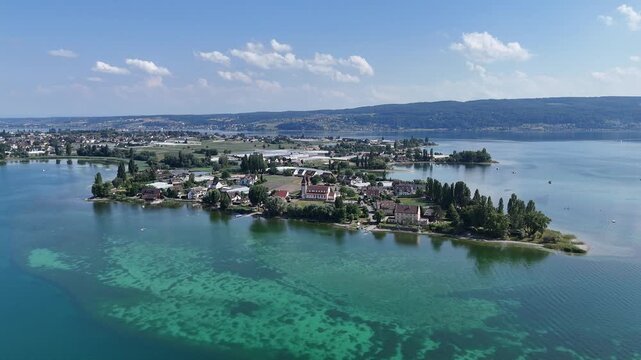 Panorama flight over Lake Constance (Bodensee) towards island Reichenau with houses and church Basilica of Sts. Peter and Paul near Konstanz, Germany