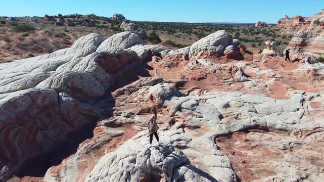 Woman standing on white pocket rock formation, traveler exploring Arizona wilderness