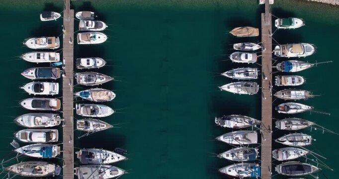 Symmetrical Marina With Carefully Placed Vessels. Overhead View Illustrating Orderly Pier Arrangement With Moored Yachts And Tranquil Green Ocean Surroundings
