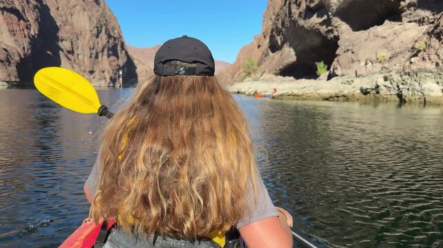 Girl kayaking on Colorado River near Hoover Dam, paddling through Black Canyon