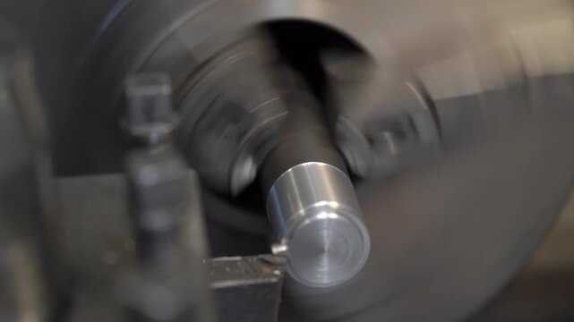 Close-up of metal part turning on a lathe machine in an industrial workshop