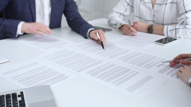 Business people discussing contract terms, outlining agreements, and reviewing legal documents during a corporate meeting, preparing for a significant partnership signing and negotiation