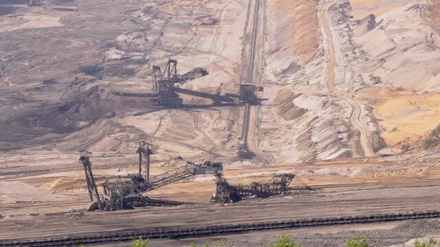 Big quarry with heavy machinery mining lignite coal in open pit min, gathering resources from earth