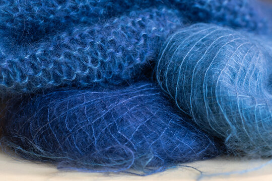 Two skeins of yarn knitted into a garter stitch scarf.