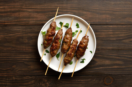 Homemade lula kebab with vegetables on wooden background